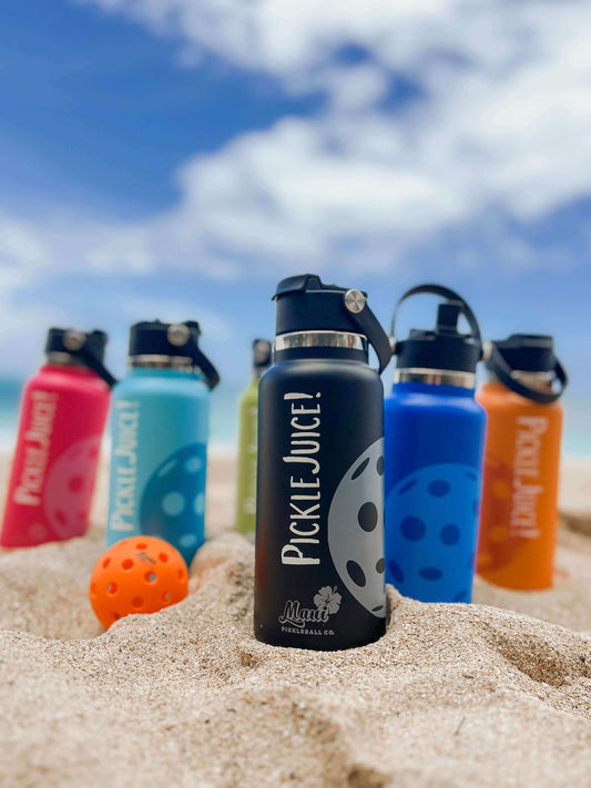 pickleball paddle on the beach with a paddle and pickleball water bottle 