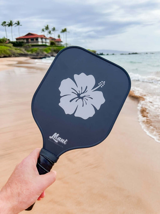 pickleball paddle on the beach with a paddle and pickleball water bottle